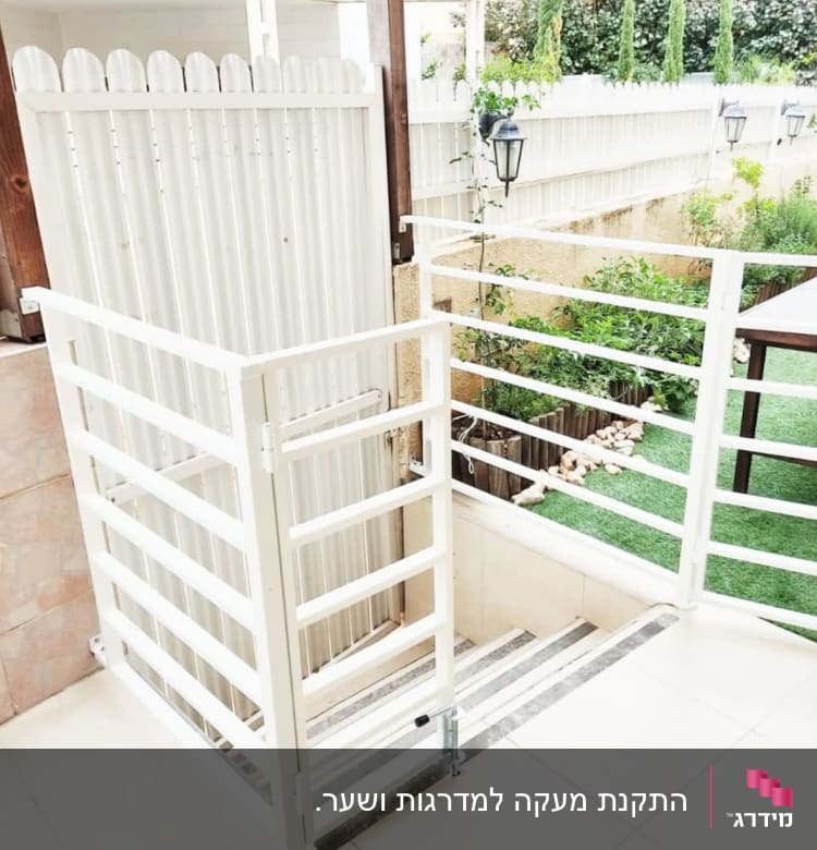 מעקה לבן עם שער ליד מדרגות